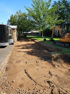 Graded residential work area with a mini excavator beside it