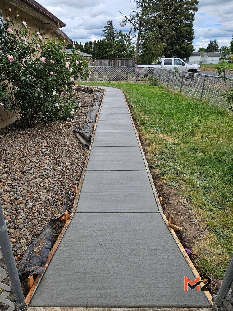 After: Finished curved concrete sidewalk installation providing clean backyard access and durable residential flatwork.