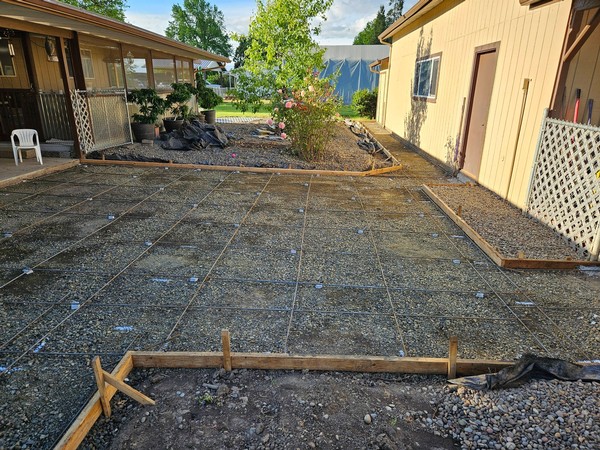 Concrete patio area prepared with compacted base and reinforced rebar grid before concrete pour.